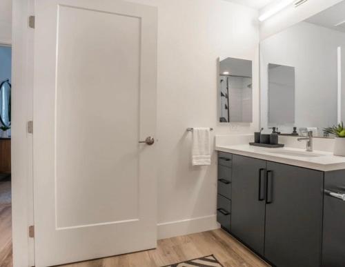 een witte badkamer met een wastafel en een spiegel bij Magic Key Two-Bedroom Escape Near Disneyland With Free Parking in Anaheim