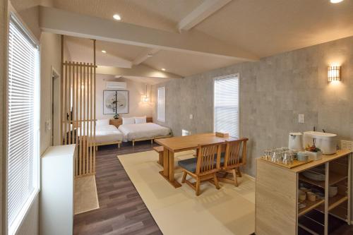 a living room with a table and a bedroom at Solana Smart INN富士河口湖 in Minamitsuru