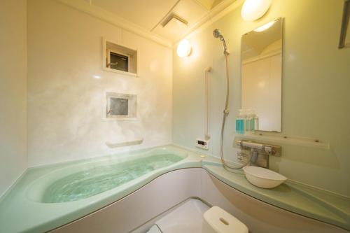 a bathroom with a tub and a toilet and a sink at Triangle 2nd in Beppu