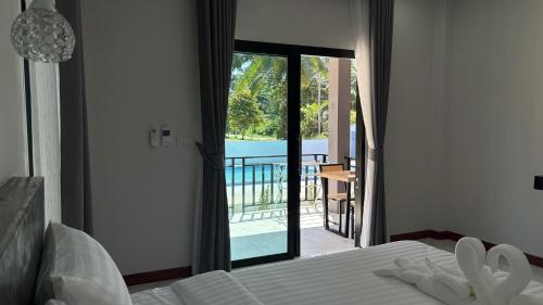 een slaapkamer met een bed en uitzicht op een balkon bij PS Lanta Resort 
