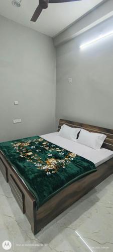 a bedroom with a bed with a green blanket on it at Sree jee stay in Varanasi