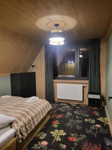 ein Schlafzimmer mit einem Bett und einem großen Teppich in der Unterkunft Białczańskie Bacówki 2, 4sypialnie in Białka Tatrzańska