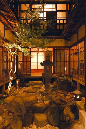 a japanese garden with a fountain in a building at 千秋楽 in Tamano