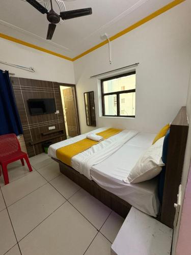 a bedroom with a large bed and a red chair at AD ressidency Hotel in Agra