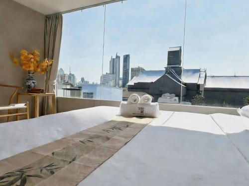 a bedroom with a bed and a large window at Chinatown No9 Boutique Hotel in Bangkok
