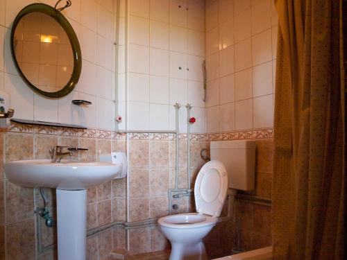 uma casa de banho com um lavatório, um WC e um espelho. em Galija em Struga