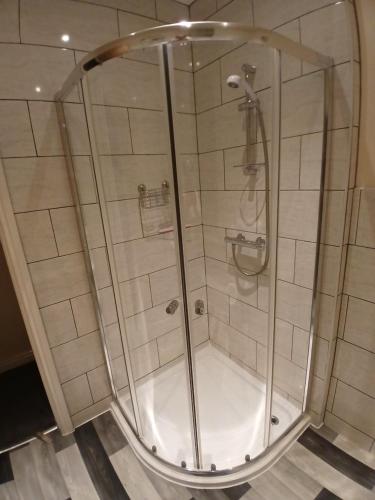 een douche met een glazen omhulsel in een badkamer bij PONDEROSA B&B with free onsite parking and breakfast included in Blackpool