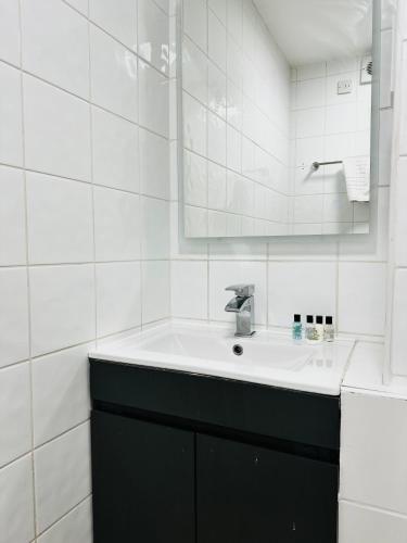 a white bathroom with a sink and a mirror at Crown Hotel - Stone, Near Stoke-On-Trent by OYO in Stone