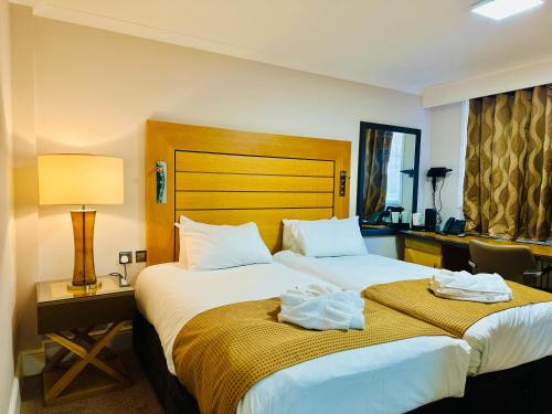 een hotelkamer met een bed met handdoeken erop bij Crown Hotel - Stone, Near Stoke-On-Trent by OYO in Stone