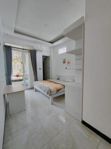 a bedroom with a bed and a desk in it at RADJIMIN Guesthouse in Adi Sutjipto