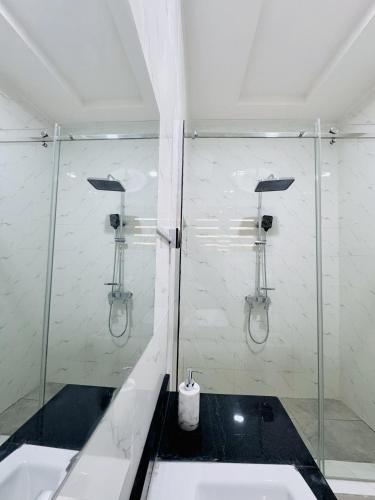 a bathroom with a glass shower and a sink at StayatMargarets in Abuja