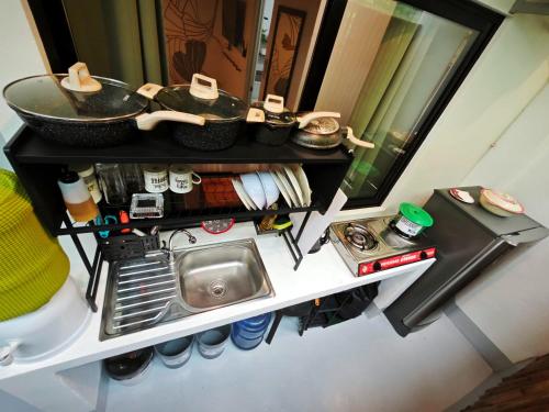 eine kleine Küche mit Spüle und Spiegel in der Unterkunft Gubat Apartelle in Lalao