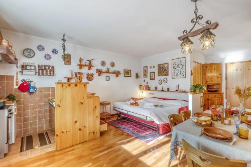 a bedroom with a bed and a table and a kitchen at Appartamento Big Lem - Happy Rentals in Sauze d'Oulx