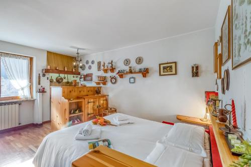 a bedroom with a large white bed and a kitchen at Appartamento Big Lem - Happy Rentals in Sauze d'Oulx