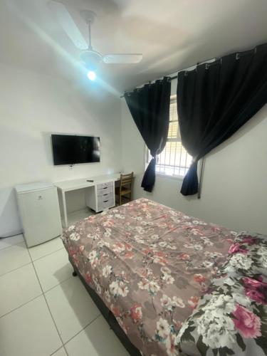a bedroom with a bed and a flat screen tv at Hostel San Pietro in Santos