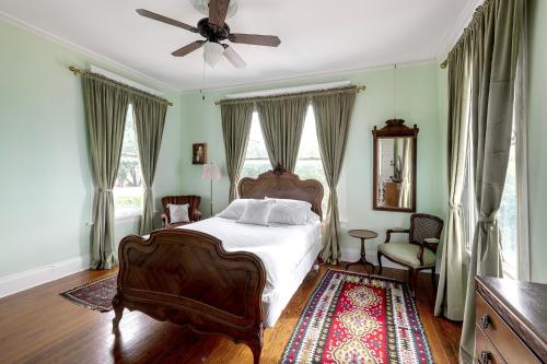 a bedroom with a bed and a ceiling fan at Heights Ironworks Bed & Breakfast in Houston