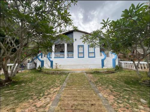 a blue and white house with trees in front of it at Recanto Cravo & Canela in Meruoca