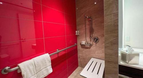 a red bathroom with a shower and a sink at Ahern Hotel and Event Center in Las Vegas