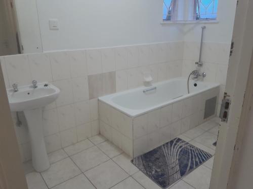 a bathroom with a bath tub and a sink at The Nexus Suites in Gaborone