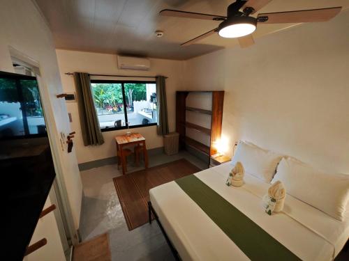 ein Schlafzimmer mit einem Bett mit zwei Schuhen drauf in der Unterkunft Gubat Apartelle in Lalao