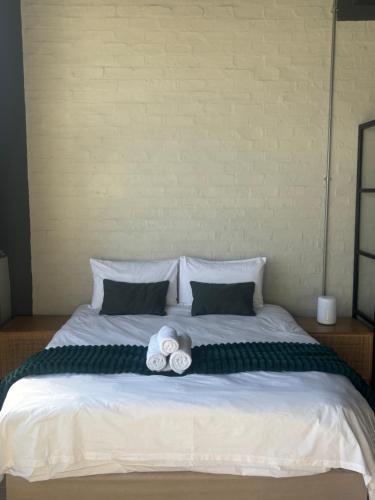 a bed with two rolls of towels on it at Studio in Woodstock in Cape Town