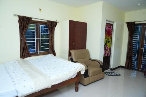 a bedroom with a bed and a chair and windows at Sparrow valley in Coonoor