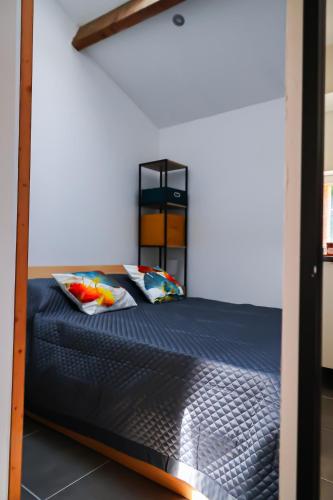 a bedroom with a bunk bed with blue sheets and pillows at Refuge de Deux Pins in La Forêt-sur-Sèvre