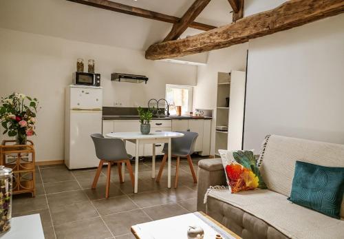 ein Wohnzimmer mit Couch und Tisch und eine Küche in der Unterkunft Gîte in La Forêt-sur-Sèvre