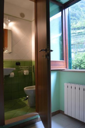 a bathroom with a toilet and a sink and a window at La Sorgente B&B in Cetara