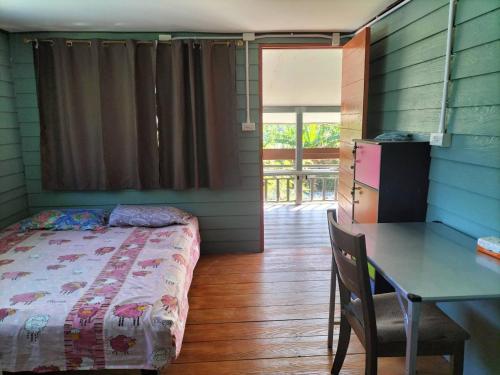 een slaapkamer met een bed, een bureau en een tafel bij Green moon Home stay 51 in Buriram