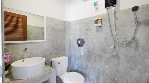 een badkamer met een douche, een toilet en een wastafel bij Three Monkeys Mae Nam beach in Nathon Bay