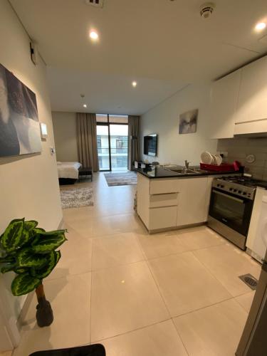 een keuken met witte kasten en een kookplaat oven bij Nuchiii Hostel in Dubai