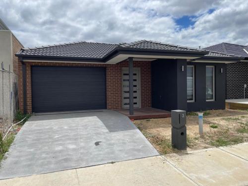 a detached house with a garage and a driveway at Southeastern Retreat in Clyde North