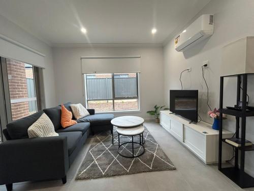 a living room with a couch and a tv at Southeastern Retreat in Clyde North