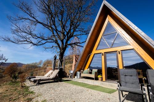 una casa con una grande finestra e un albero di Dream Cottage A-Frame a Şinca Nouă