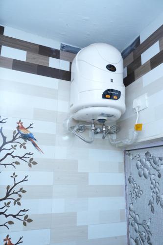 a bird on the wall of a bathroom with a camera at Sparrow valley in Coonoor