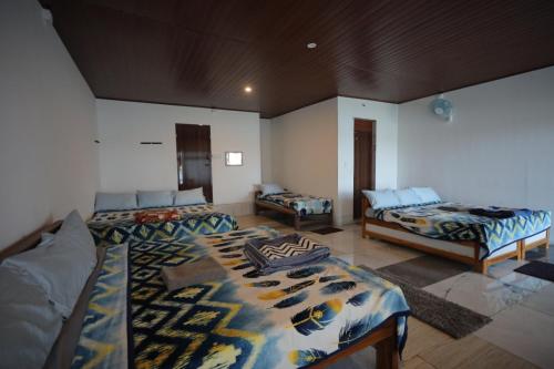 a large room with two beds and a couch at Coorg Backwaters in Suntikoppa