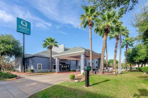 a sign in front of a hotel with palm trees at Quality Suites Houston NW Cy-Fair in Houston