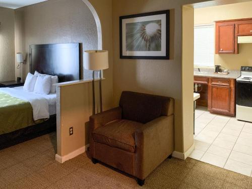 a hotel room with a bed and a chair at Quality Suites Houston NW Cy-Fair in Houston
