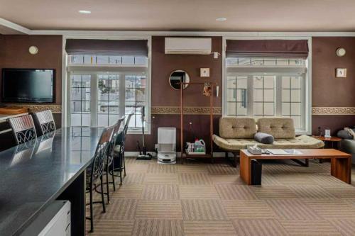 美瑛町Biei Terrace 2F 専用玄関 127平米 85型スマートTV -駅前通り&景観条例地区-的客厅里有一张沙发和一张桌子。