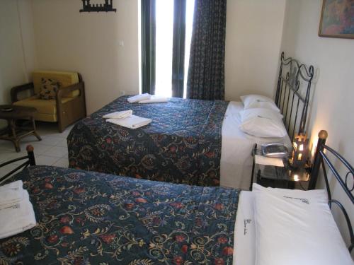 a hotel room with two beds and a chair at Castle View Studios in Paralion astros