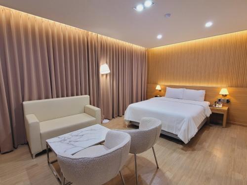 a hotel room with a bed and a table and chairs at 호텔휴 