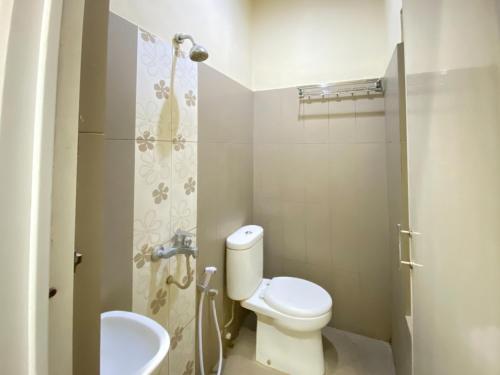 a small bathroom with a toilet and a sink at Lily Guest House Syariah RedPartner in Bunul