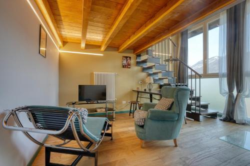 een woonkamer met stoelen en een trap bij La Casetta di Renzo e Lucia in Olginate