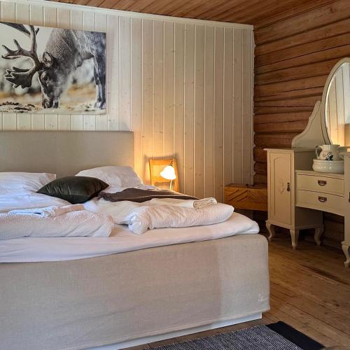 a bedroom with a bed and a picture of a deer at Charming Guesthouse farm in Hølera
