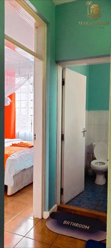 an open door to a bedroom with a bed and a toilet at Makasembo breeze homes in Kisumu
