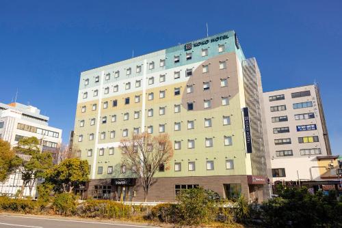 a large building in a city with a street at KOKO HOTEL Higashiosaka - formerly Hotel Wing International Select Higashi Osaka in Osaka