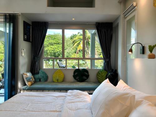 a bedroom with a bed and a large window at บ้านสวนปรีดา-Preda Garden Home in Sam Phran