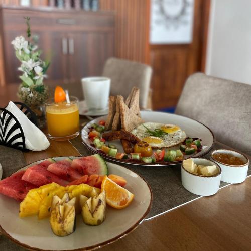 a table with two plates of breakfast food on it at Odyssey Boutique Hotel in Arugam Bay