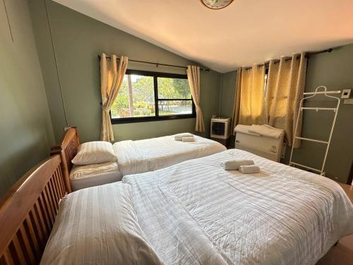 een slaapkamer met 2 aparte bedden en een raam bij Bann Kieng Kiri in Mu Si